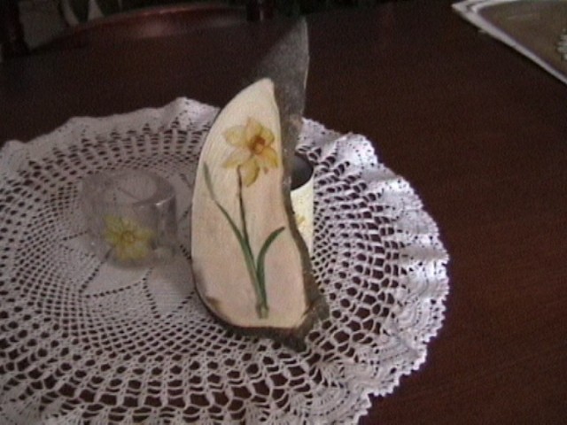 Svečnik s servetko in isti motiv na rezini češnje ali fige. Žal je bil les presvež in se j