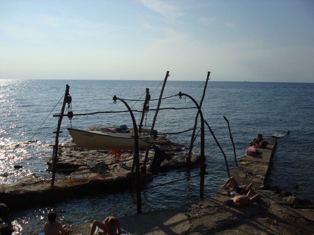 Značilna lesena kolišča z ribiškimi mrežami in čolni