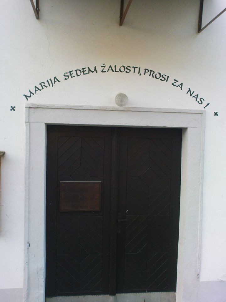 napis nad cerkvenimi vrati Device Marije v Podlehniku
