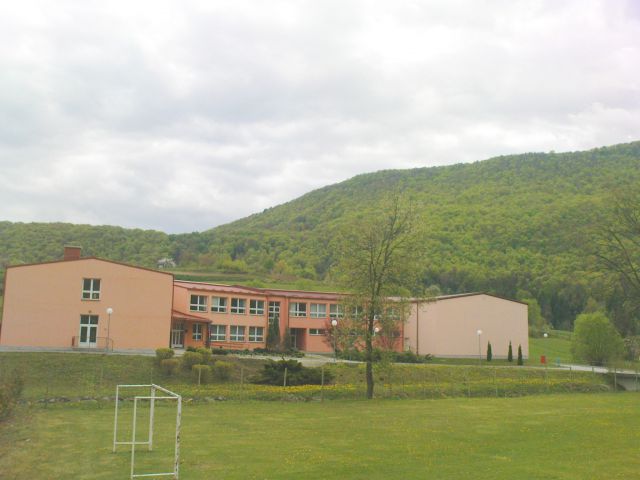 Lepa osnovna šola v Višnjici,nad njo pogorje Ravne gore