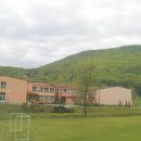 lepa osnovna šola v Višnjici,nad njo pogorje Ravne gore