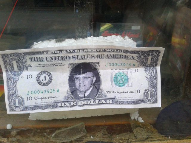 Z dolarjem zalepljena luknja v steklu