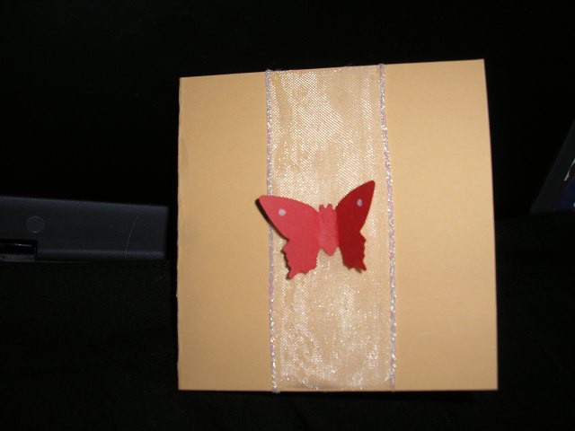 Metuljček je izrezan z puncherjem in nalepljen le po sredini, da se krila lahko zavihajo. 