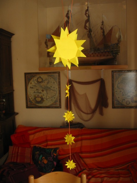 Origami sončki, povezani z nitko v mobile za darilo mali Manci